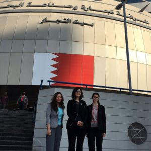Millie Chu, Diana Paez-Cook and Kristin Babbie stand in front of the Bahrain Chamber of Commerce and Industry Building.