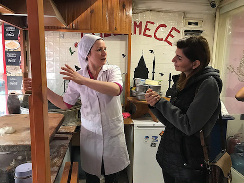 A member of the LIFE project consortium speaks with a Turkish business owner of a small crepe restaurant about her perspective on hiring people of different cultures, including Syrian refugees.